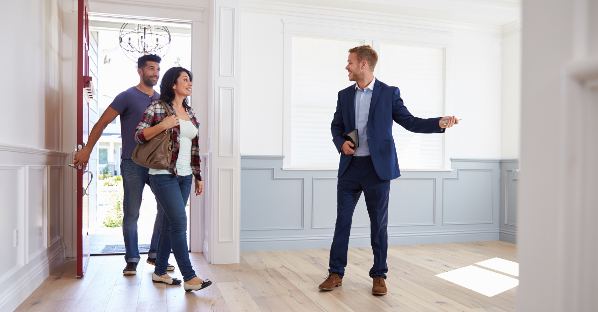 realtor showing young couple a house